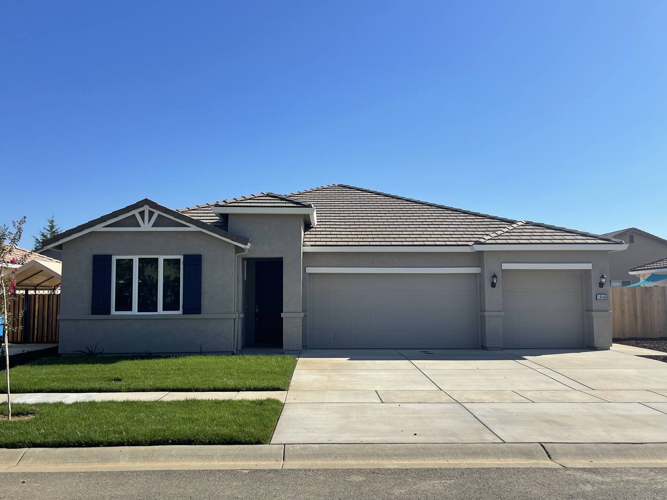 Completed Oak Grove Estates home: single-story with three-car garage, tile roof and landscaped front yard